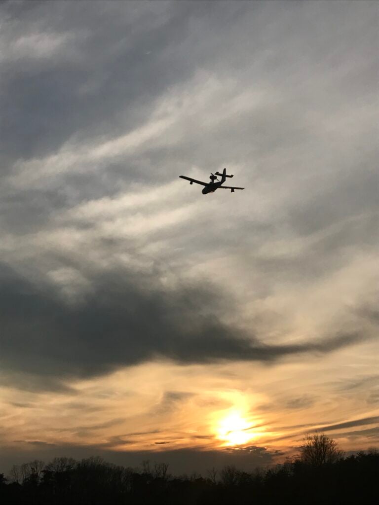 Small airplane flying through a sunset sky, reflecting the aviation spirit of Bedford Landings Bed & Breakfast near Smith Mountain Lake, Virginia.