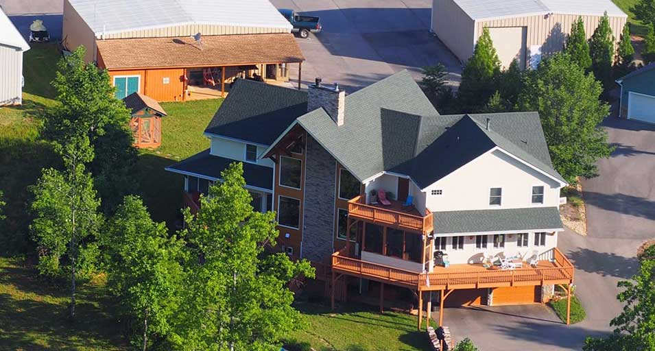 Aerial exterior view of Bedford Landings Bed & Breakfast near Smith Mountain Lake, showing the timber-frame inn, decks, trees, and surrounding property.