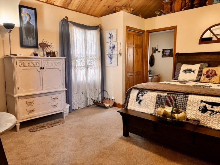 Fishing-themed guest room at Bedford Landings Bed & Breakfast near Smith Mountain Lake, featuring a rustic wood ceiling, cozy quilted bed, warm natural light, and lake-inspired decor.