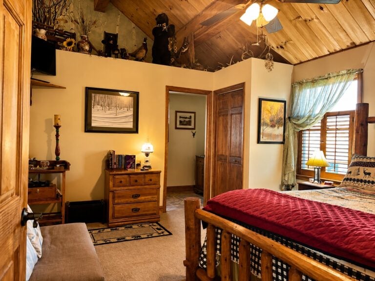 Forest-themed guest room at Bedford Landings Bed & Breakfast near Smith Mountain Lake, featuring a rustic wood bed, vaulted wood ceiling, warm natural light, and lodge-inspired decor.