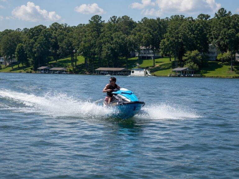 Person riding a jet ski across Smith Mountain Lake near Bedford Landings Bed & Breakfast on a sunny day.