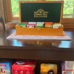 Shared guest tea station at Bedford Landings Bed & Breakfast near Smith Mountain Lake, featuring assorted teas, teapots, mugs, and a wooden tea display.