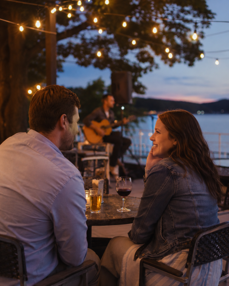 Couple enjoying a relaxed date night on an outdoor patio near Smith Mountain Lake with string lights, acoustic live music, lake views, and a warm evening atmosphere.